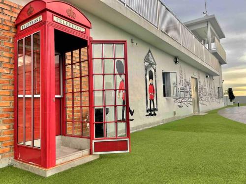 a red phone booth in front of a building at The Venus - Spacious Wooden TOP Floor Apartment in Sitiawan
