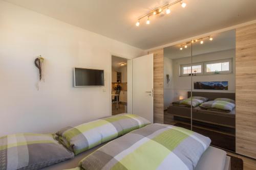 1 dormitorio con 2 camas y TV en la pared en Ferienwohnung Blickfang en Garmisch-Partenkirchen