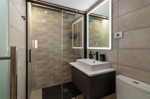 La salle de bains est pourvue d'un lavabo et d'une douche en verre. dans l'établissement CASA ADA, à Melenara