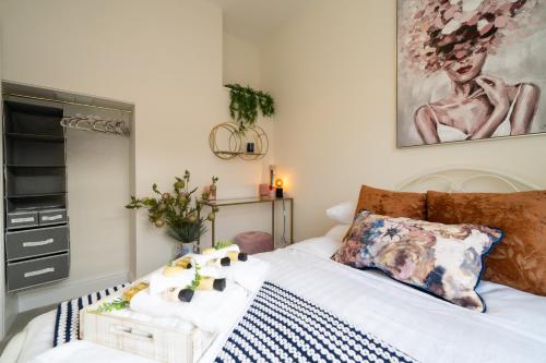 a bedroom with a bed and a painting on the wall at The Regal Apartment in Royal Tunbridge Wells