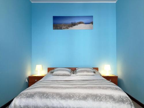 コウォブジェクにあるApartament 2-pokojowy ul. Portowa 14の青いベッドルーム(大型ベッド1台、ランプ2つ付)
