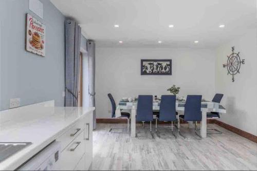 a dining room with a table and blue chairs at Wonderful Coastal home in Dingle town in Dingle