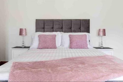 a bedroom with a large bed with two pink pillows at Wonderful Coastal home in Dingle town in Dingle