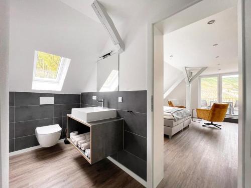 Un baño con lavabo, inodoro y una cama. en Villa Burglay, en Zell an der Mosel