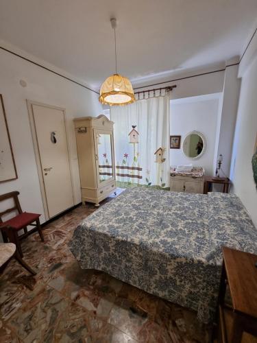 a bedroom with a bed and a chair and a window at Villa Pina in Laigueglia
