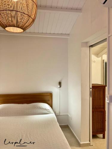 a bedroom with a bed and a chandelier at 17 Les Palmes - Maison de charme - Piscine privée et accès plage in Sainte-Anne