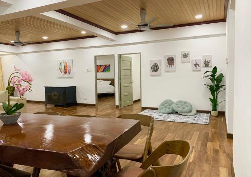 a dining room with a table and chairs and a bedroom at The Venus - Spacious Wooden TOP Floor Apartment in Sitiawan