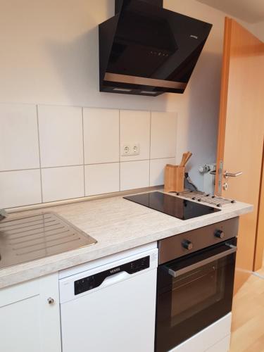 cocina con fregadero y fogones horno superior en Haus Gerda, en Gersfeld
