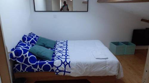 a bedroom with a bed with blue and white pillows at Appartement La JOIE dans quartier chic in Pibrac