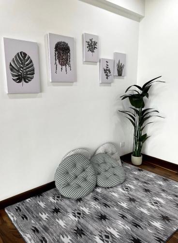 a living room with two chairs and a wall with pictures at The Venus - Spacious Wooden TOP Floor Apartment in Sitiawan