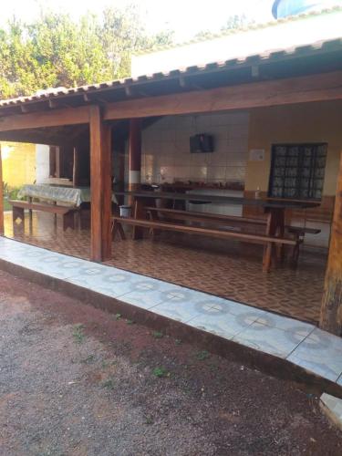 um pavilhão com uma mesa e bancos num quintal em Pousada Mato Grosso em Nobres