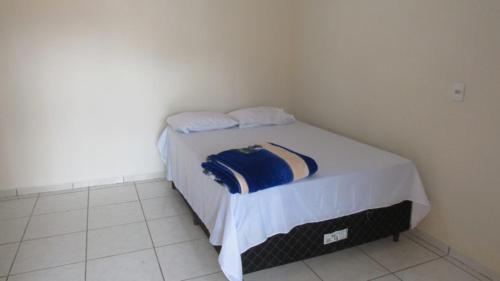 a bedroom with a bed with white sheets and pillows at Pousada Mato Grosso in Nobres