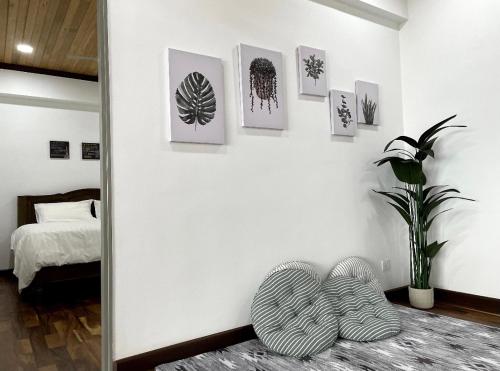 um quarto com uma parede branca com fotografias na parede em The Venus - Spacious Wooden TOP Floor Apartment em Sitiawan