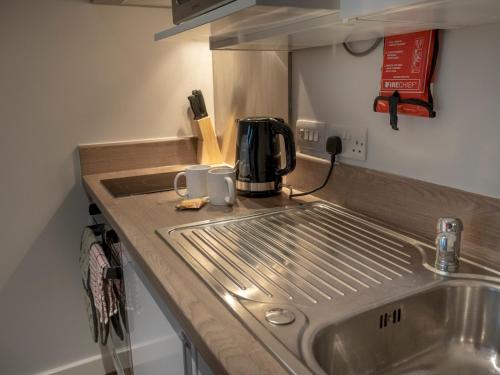 a kitchen counter with a sink and a coffee maker at Pass The Keys Cosy High Street Studio with Free Parking in Lincoln