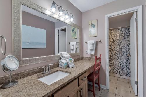 a bathroom with a sink and a large mirror at Phoenix 6 Unit 1209 in Orange Beach