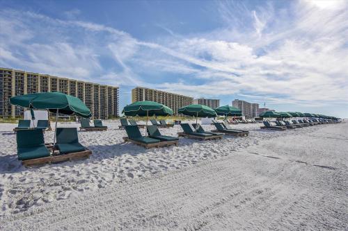 a row of chairs and umbrellas on a beach at Phoenix 6 Unit 1209 in Orange Beach