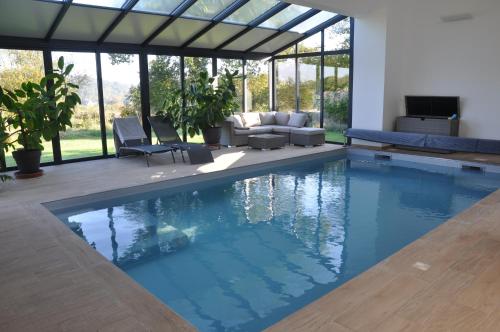 une piscine dans une maison avec un salon dans l'établissement La Vallée, à Saint-Pierre-Langers