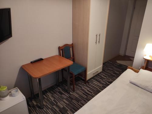a room with a table and a bed and a desk at Pod Różą B&B in Ustka