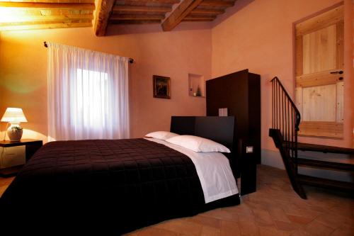 a bedroom with a black bed and a staircase at La Locanda del Vino Nobile in Sant'Albino