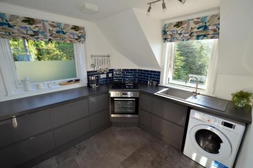 a kitchen with a sink and a washing machine at The View at Pier House Glencoe in Glencoe