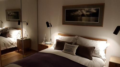 a bedroom with a large bed with pillows on it at The View at Pier House Glencoe in Glencoe