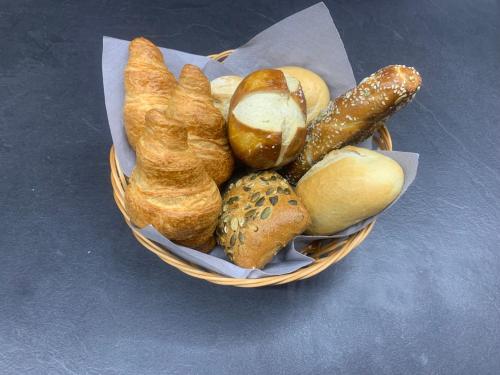a basket of bread and pastries on a table at FeWo WOW! TOP Lage! Schöne 2-Zimmer Wohnung! in Weisweil