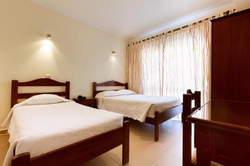 a bedroom with two beds and a window at Ribeiro Hotel in Fátima