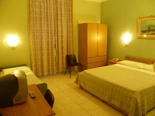Pokój hotelowy z 2 łóżkami, biurkiem i krzesłem w obiekcie Hotel Pensione Romeo w mieście Bari