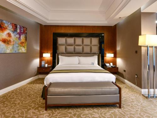 a bedroom with a large bed and two lamps at Best Plaza West Bay Hotel in Doha
