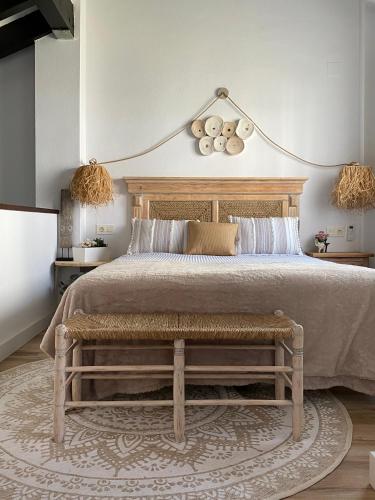 a bedroom with a large bed with a bench at El Capricho in El Ronquillo