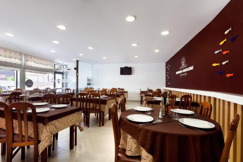 un comedor con mesas y sillas en un restaurante en Ribeiro Hotel, en Fátima
