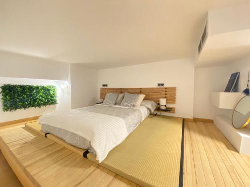 - une chambre avec un grand lit et une tête de lit en bois dans l'établissement Cozy designer apart / Acogedor apartamento de diseño ● WiFi - Jacuzzi - A/C SteamSauna, à Madrid