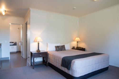 1 dormitorio con 1 cama y 2 lámparas en una mesa en Executive On Fenton, en Rotorua