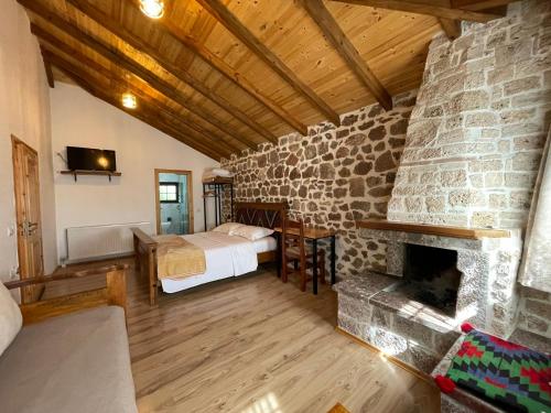 1 dormitorio con 1 cama y chimenea de piedra en Bujtina Liana Voskopoje, en Voskopojë
