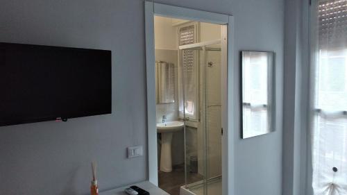 baño con TV y lavabo en casa serrati(locanda la cascina)camera con bagno privato ma cucina in comune, en San Giuliano Milanese