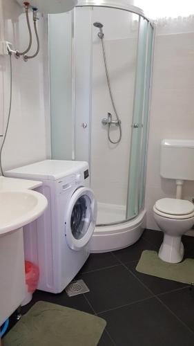 a bathroom with a washing machine next to a toilet at Apartment Zorica in Vodice