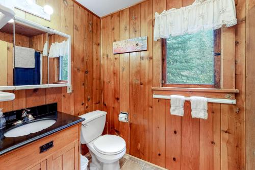 een badkamer met een toilet, een wastafel en een raam bij Moccasin Lake in Joseph