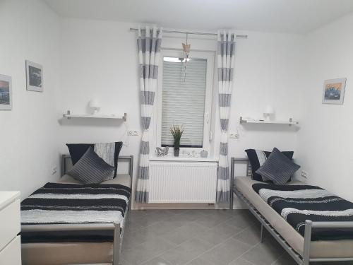 two beds in a room with a window at Ella's Wolke Appartements - EW5 in Zweibrücken