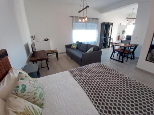 a bedroom with a bed and a living room at Pipo People House in Óbidos