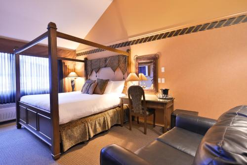 Habitación de hotel con cama, escritorio, cama y sofá en Prestige Vernon Hotel, en Vernon