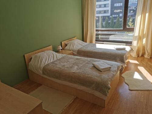 two beds in a small room with a window at Na planina in Razlog