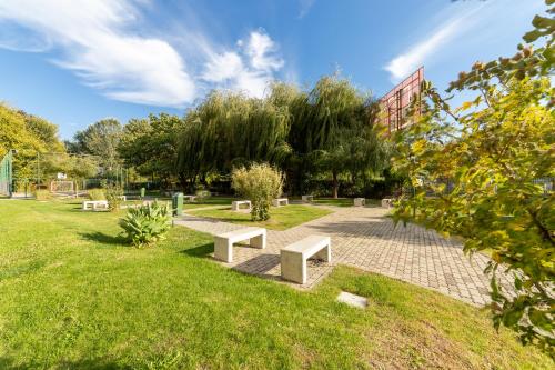 a park with benches on the grass and a building at ARI - ARED Luxurious Apartments with Balcony & Free Parking in Arad