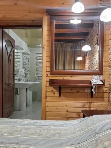a bedroom with a bed and a mirror and a sink at Elf-cottage in Turʼya Paseka