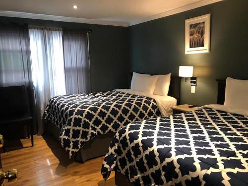 a hotel room with two beds and a window at Jones Beach Hotel in Wantagh