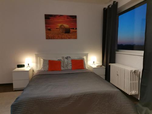 ein Schlafzimmer mit einem Bett mit orangefarbenen Kissen und einem Fenster in der Unterkunft STUDIO Piata Victoriei (Victoriei Square) in Bukarest