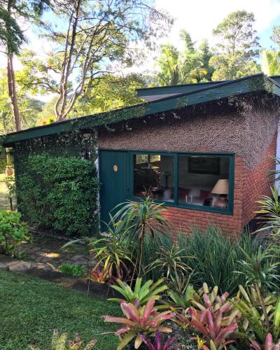 a red brick house with a green door at Pinheiros do Rocio in Petrópolis