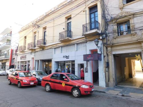 two red cars parked in front of a building at Hostal Vampayá in Salta