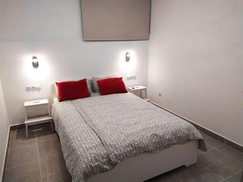 a bedroom with a large bed with two red pillows at Modern 1 bed Apartment Cristianos in Arona