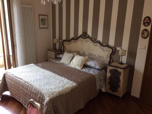 ein Schlafzimmer mit einem Bett und zwei Nachttischen und zwei Lampen in der Unterkunft CASA LE ROSE in Arezzo