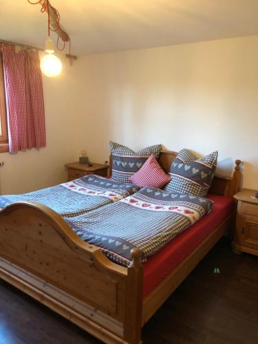 フュッセンにあるAllgäuglück - natur & stadtnahのベッドルーム1室(木製ベッド1台、カラフルな枕付)